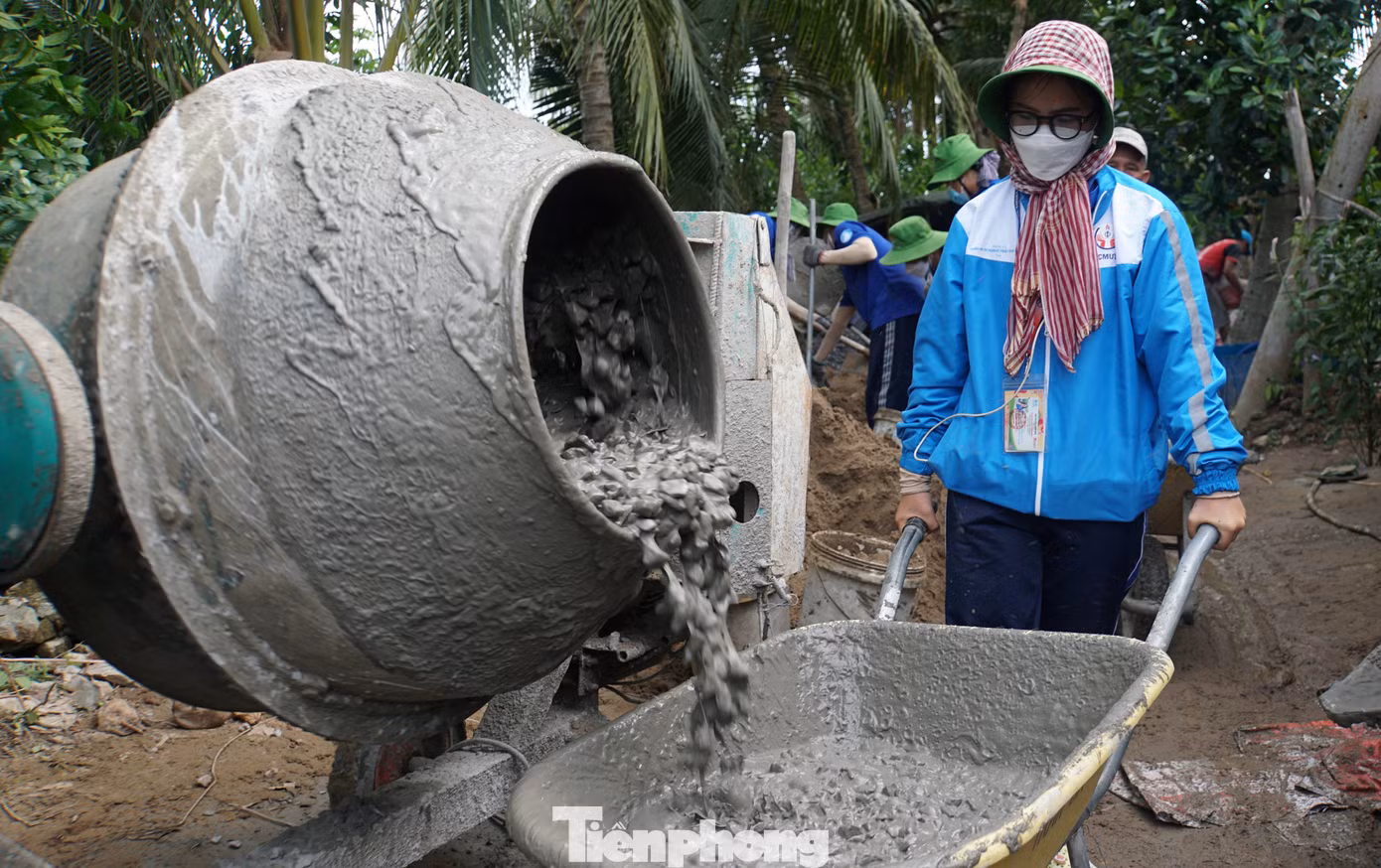 Bạn Lê Kim Ngân, Chỉ huy trưởng chiến dịch Mùa hè xanh Khoa kinh tế, Trường đại học Sư phạm kỹ thuật TP.HCM cùng các thành viên trong đội làm đường giao thông nông thôn giúp bà con.