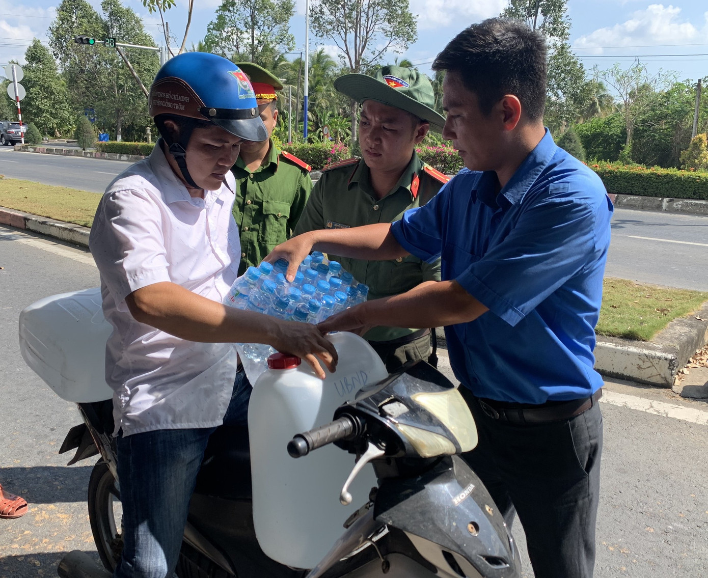 Đoàn viên thanh niên cùng chiến sĩ công an Bến Tre hỗ trợ nước ngọt cho người dân.