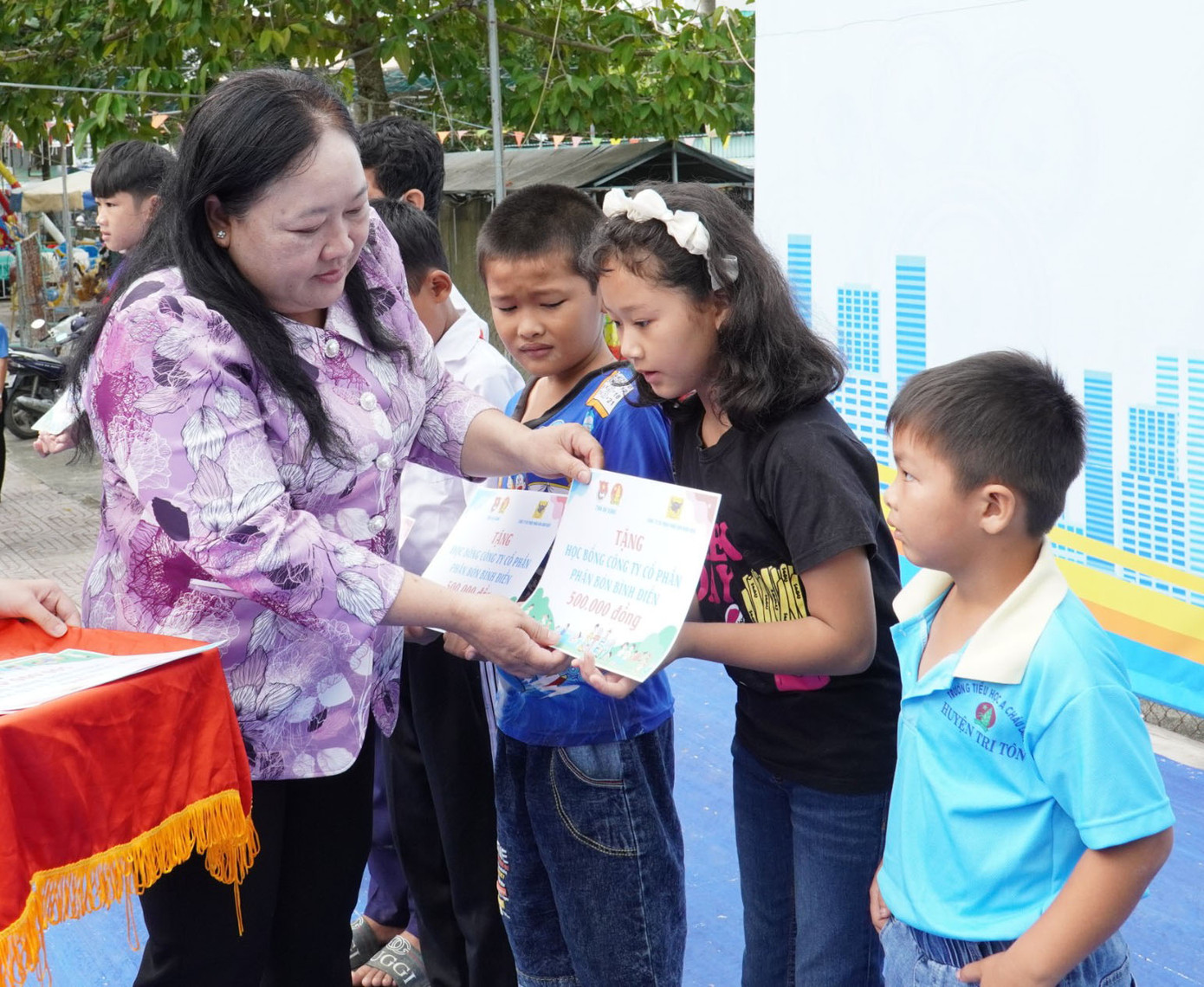 Bà Nguyễn Thị Liêm, Phó trưởng Ban Dân vận Tỉnh ủy An Giang tặng quà cho học sinh.