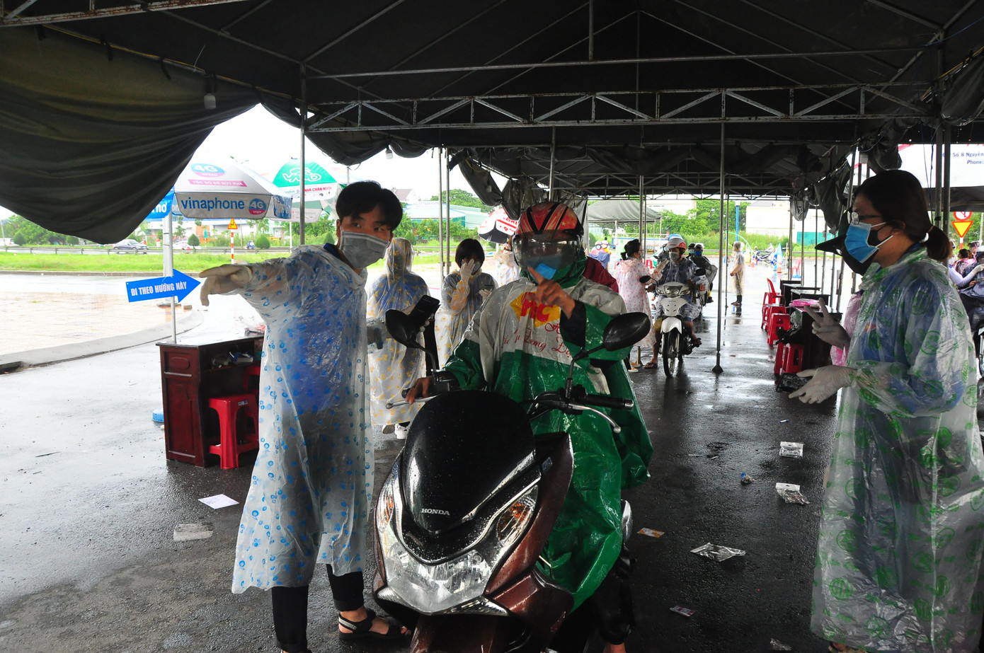 Các bạn trẻ mặc áo mưa làm nhiệm vụ