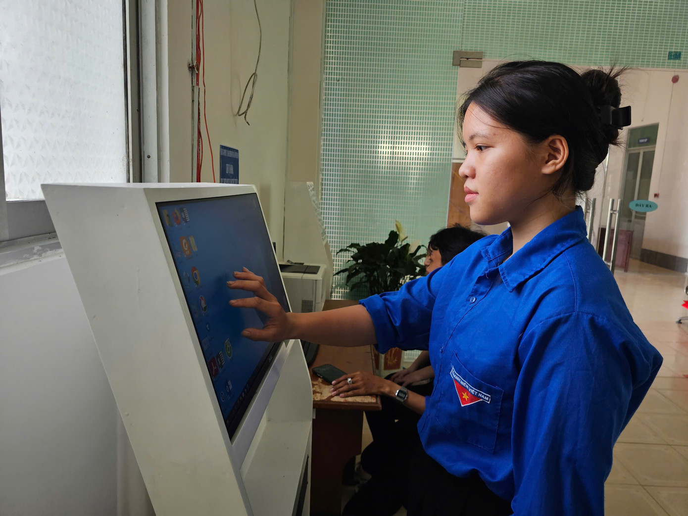 Đoàn viên, thanh niên có mặt từ sớm tại trung tâm hành chính công xã Vĩnh Thạnh hỗ trợ người dân tra cứu và nộp hồ sơ trực tuyến. Ảnh: Hòa Hội