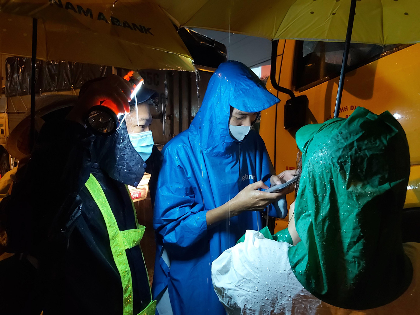 Người rọi đèn, người che dù còn người nhập dữ liệu khai báo y tế. - Ảnh: Hòa Hội