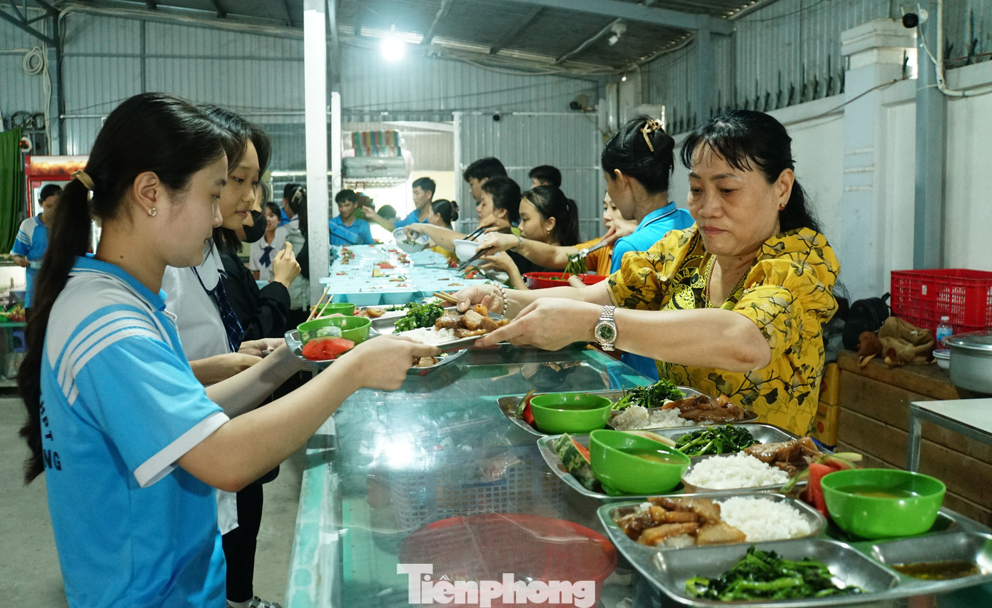 Các em học sinh sau giờ học buổi sáng, đến nhận cơm trưa. Ảnh: Hòa Hội