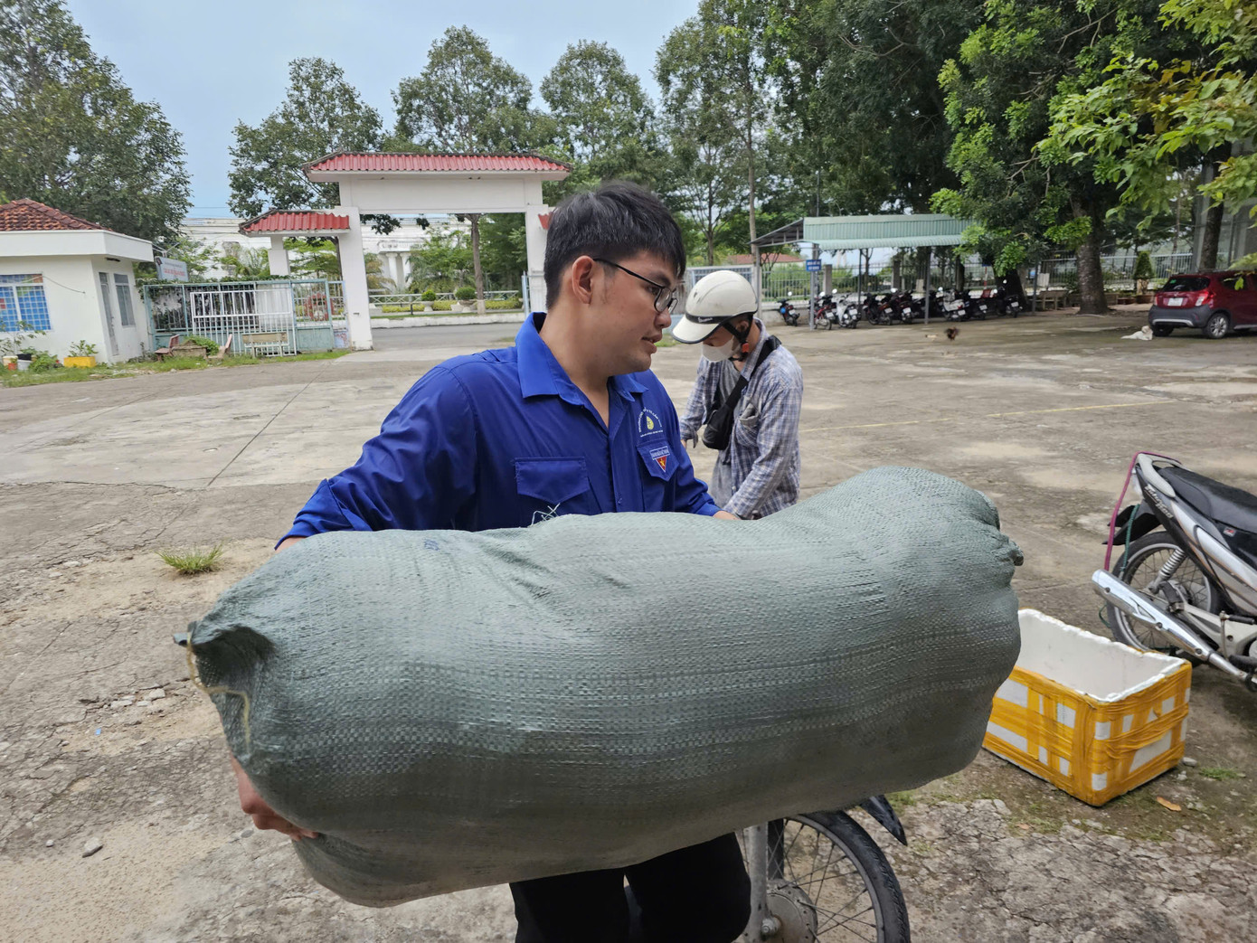Tình nguyện viên hỗ trợ mang đồ vào điểm tập kết. Ảnh: Hòa Hội
