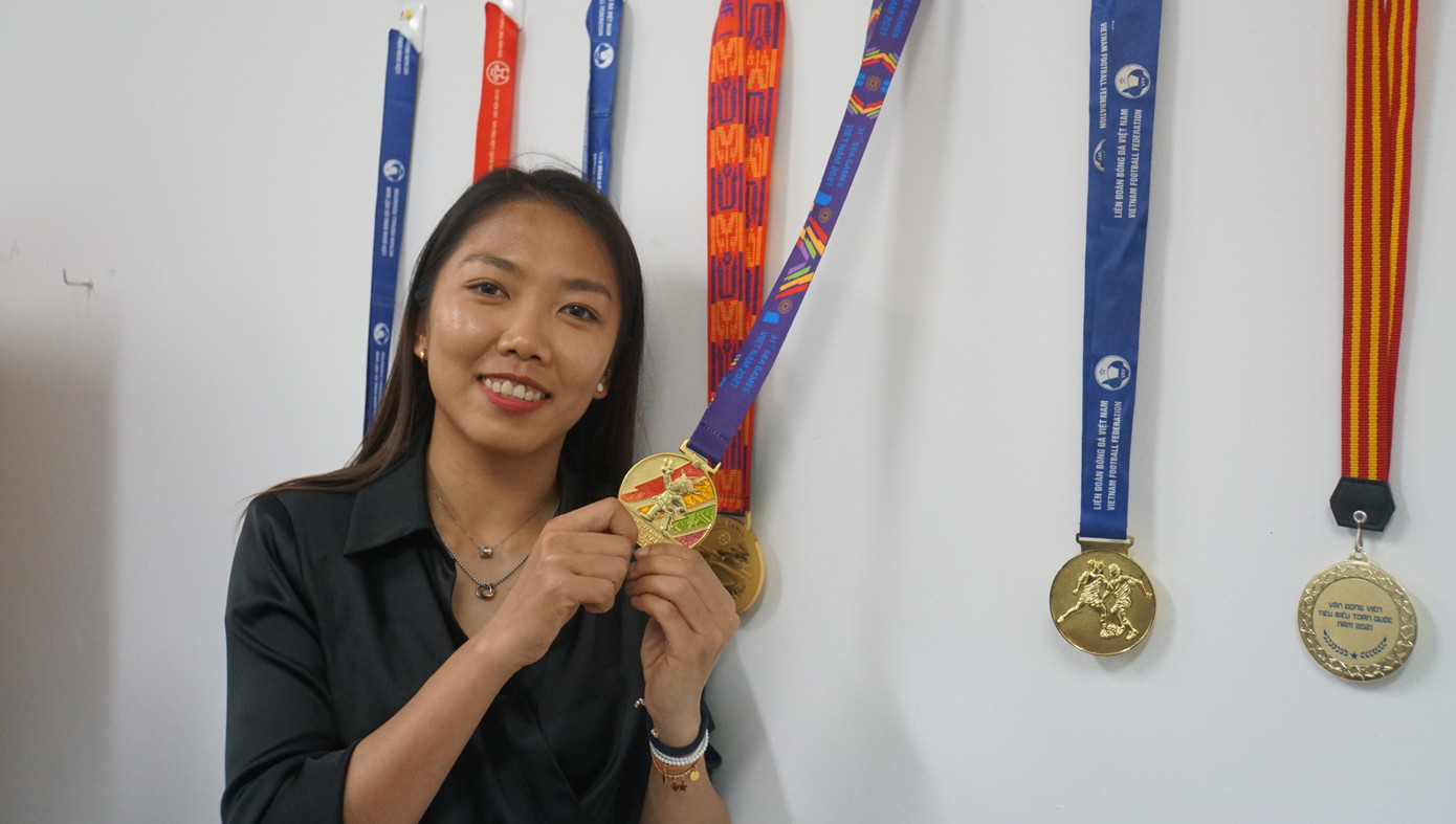 Huỳnh Như bên cạnh bộ sưu tập huy chương của mình được trưng bày tại trường Đại học Trà Vinh. Ảnh: Hòa Bình