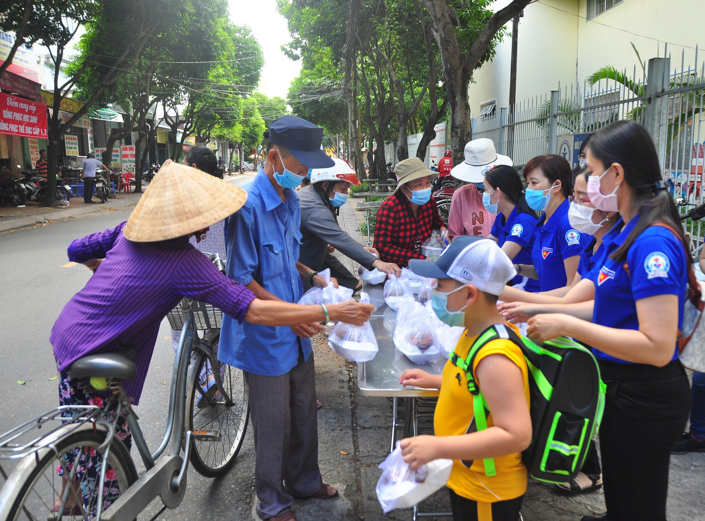 Người dân đi bán vé số rồi tranh thủ ghé nhận cơm về ăn trưa. Họ chia sẻ, mấy hôm nay buôn bán ế ẩm, cuộc sống chật vật nên có được món quà này vô cùng ý nghĩa và ấm áp.