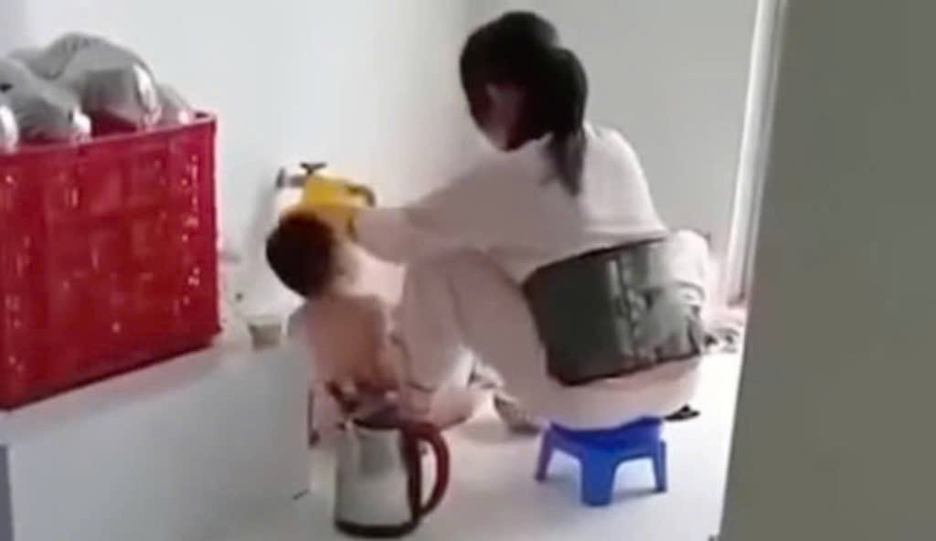 Nhân viên nấu ăn nhóm mầm non Thu Sương (Ba Tri, Bến Tre) nhồi nhét thức ăn vào miệng trẻ em. Ảnh cắt từ clip.