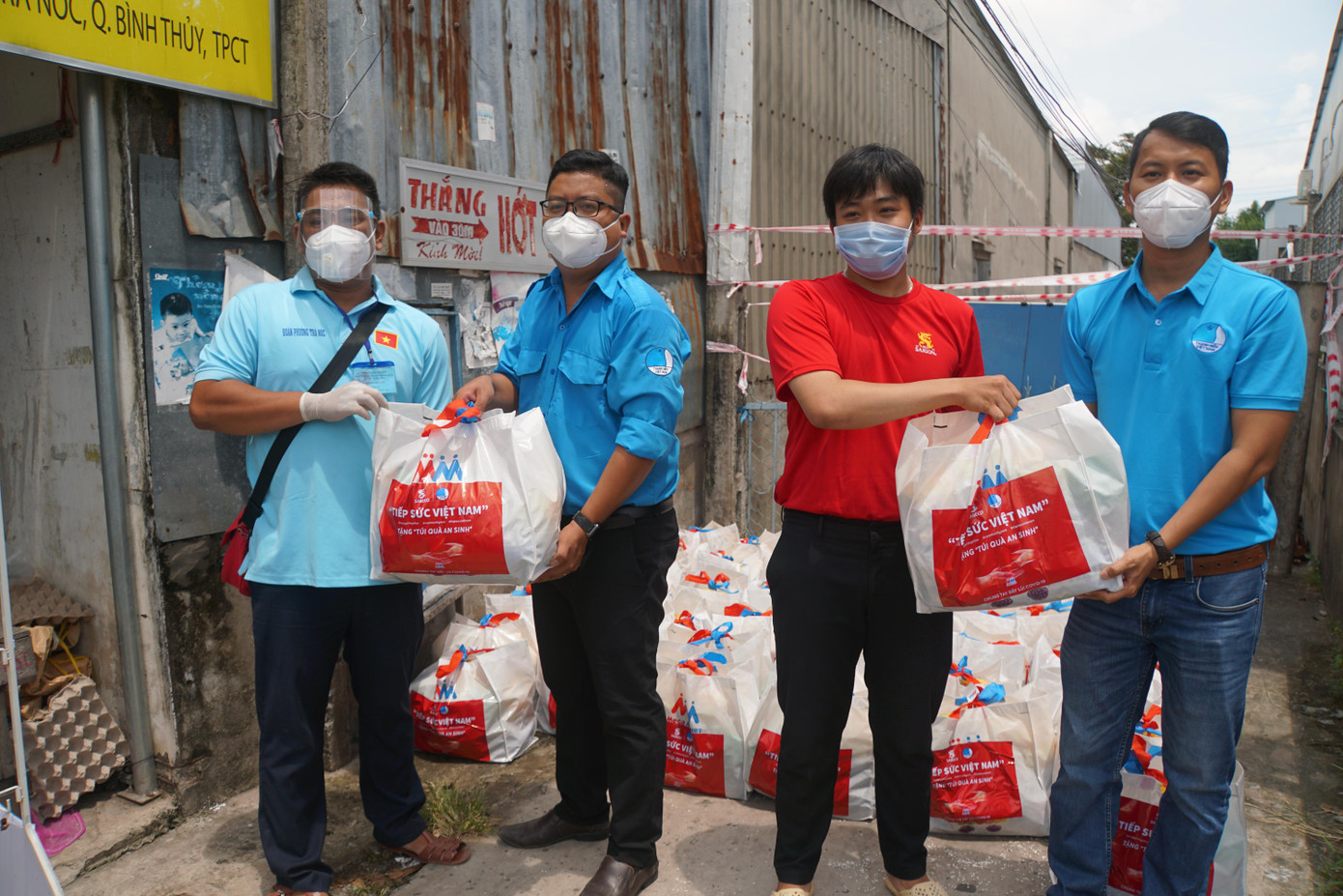 Anh Trần Việt Tuấn (thứ 2 từ trái sang) tặng quà cho đại diện Quận, phường Đoàn