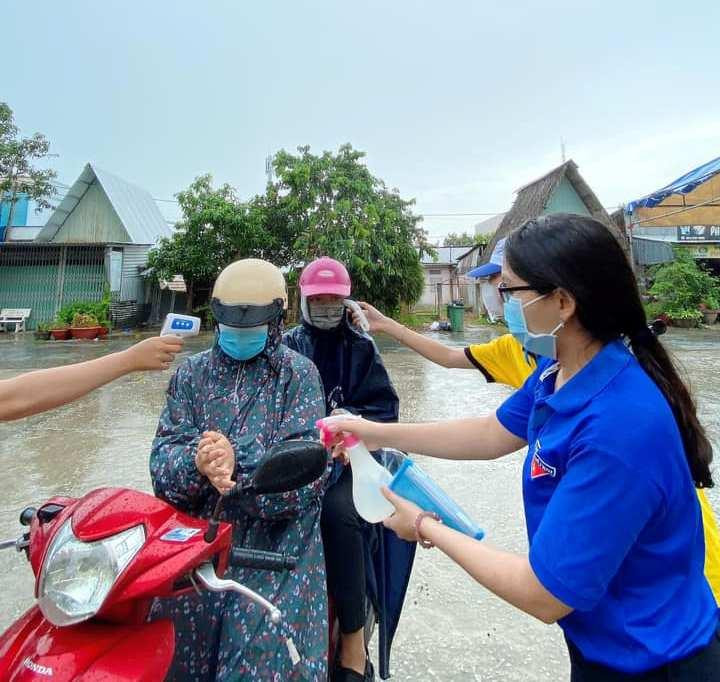 Tình nguyện viên sát khuẩn và đo nhiệt độ thí sinh