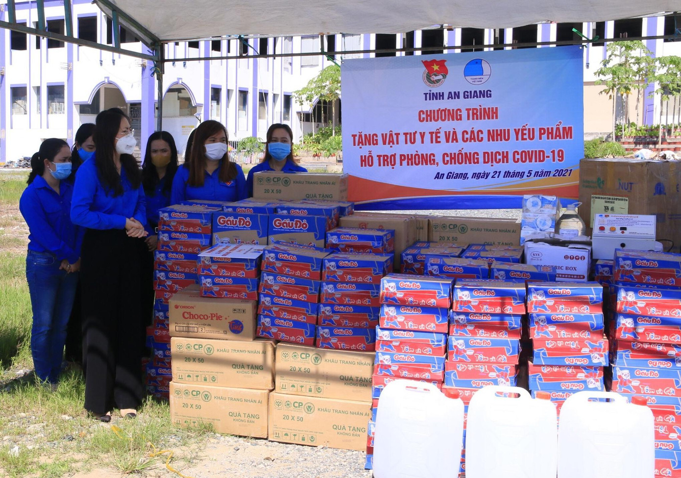 Chị Võ Thị Thủy Tiên, Phó Bí thư Tỉnh đoàn An Giang đứng cạnh vật tư y tế và nhu yếu phẩm để trao tặng cho người dân tỉnh Tà Keo