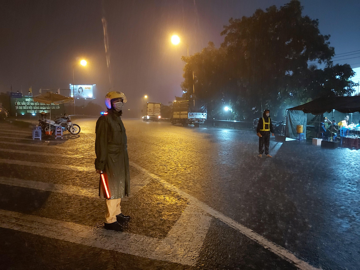 Cảnh sát giao thông dầm mưa làm nhiệm vụ. - Ảnh: Hòa Hội