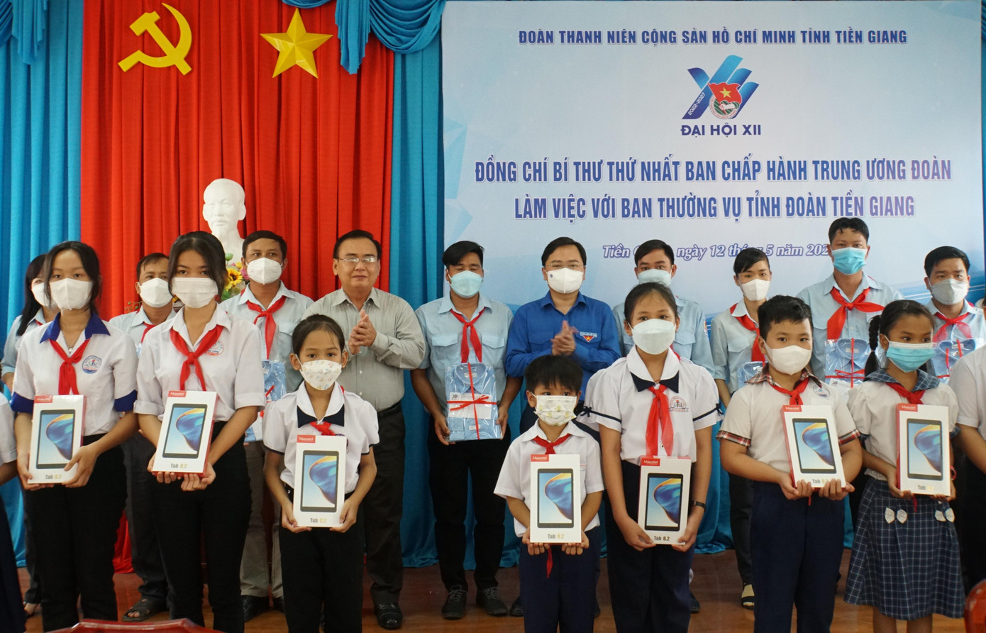 Anh Nguyễn Anh Tuấn cùng lãnh đạo Tỉnh ủy Tiền Giang tặng quà cho giáo viên Tổng phụ trách Đội và học sinh khó khăn. - Ảnh: Hòa Hội