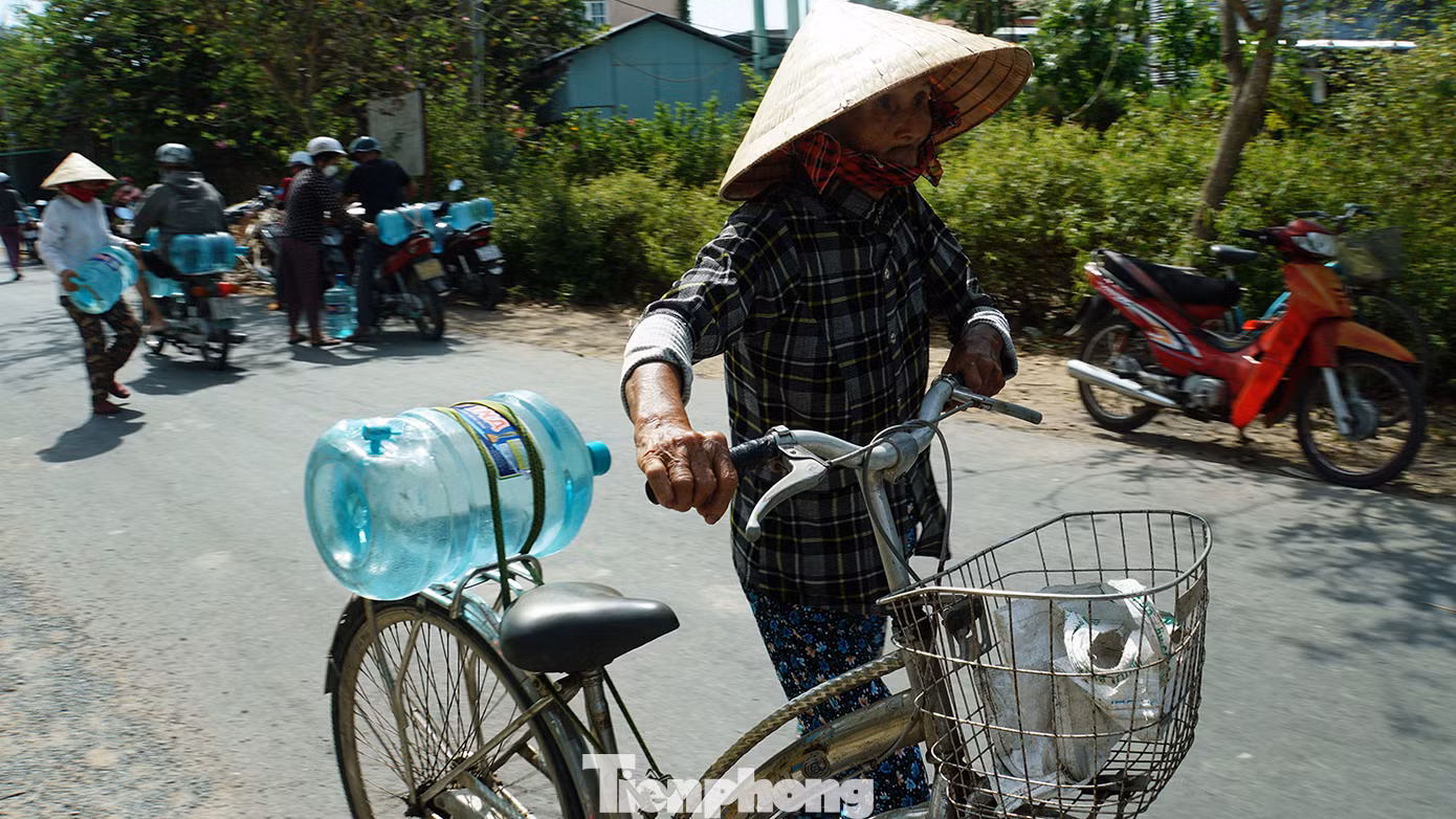Cụ già đẩy xe nước về nhà. Ảnh: Hòa Hội