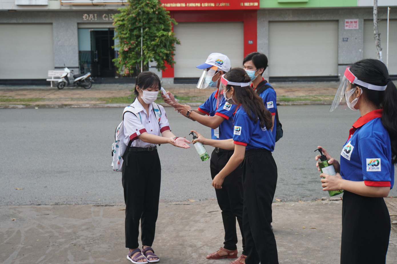 Tình nguyện viên đo thân nhiệt và sát khuẩn cho thí sinh. - Ảnh: Hòa Hội Tình nguyện viên đo thân nhiệt và sát khuẩn cho thí sinh. - Ảnh: Hòa Hội