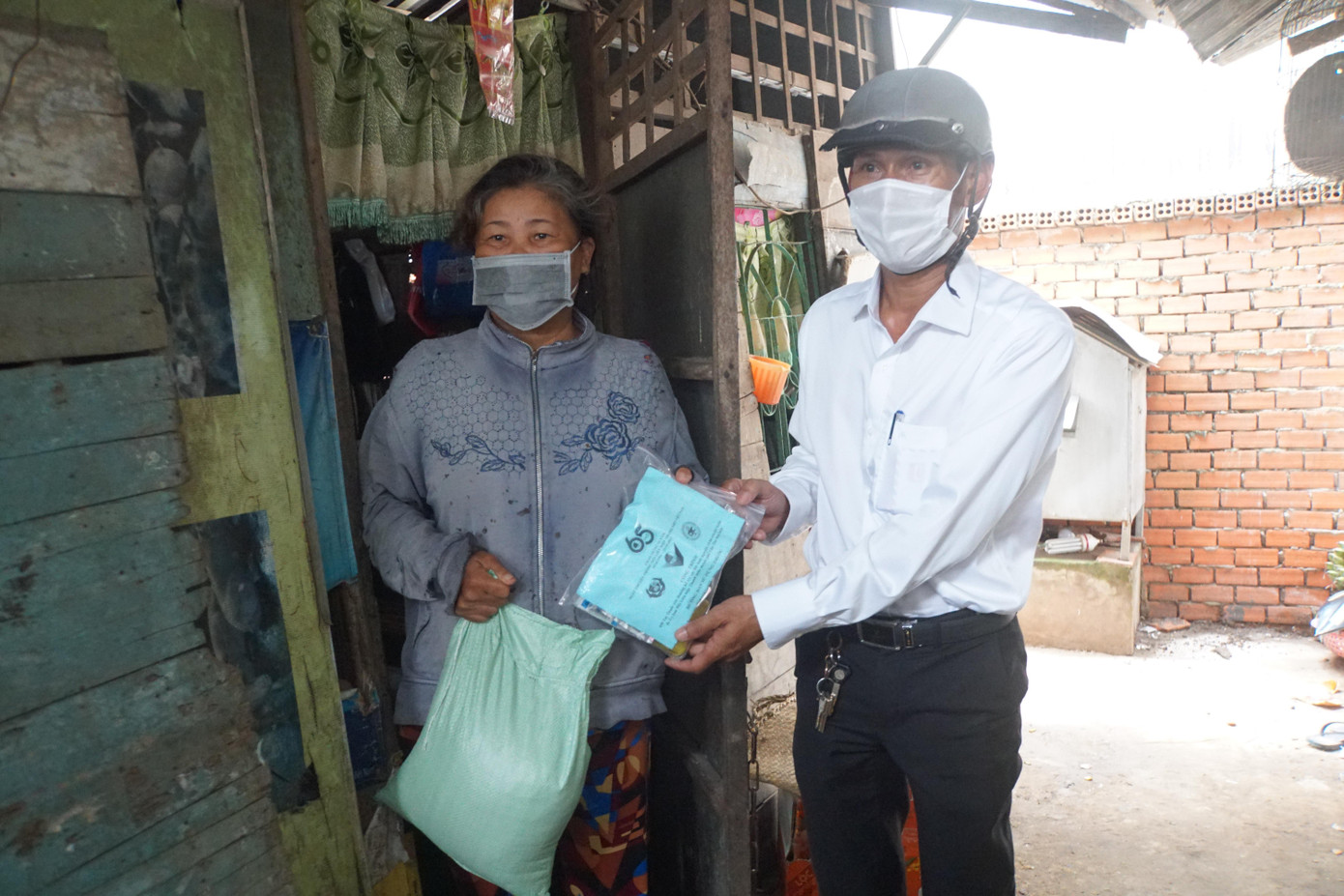 Đại diện chính quyền địa phương trao tặng thuốc cho bà Lê Thị Dí