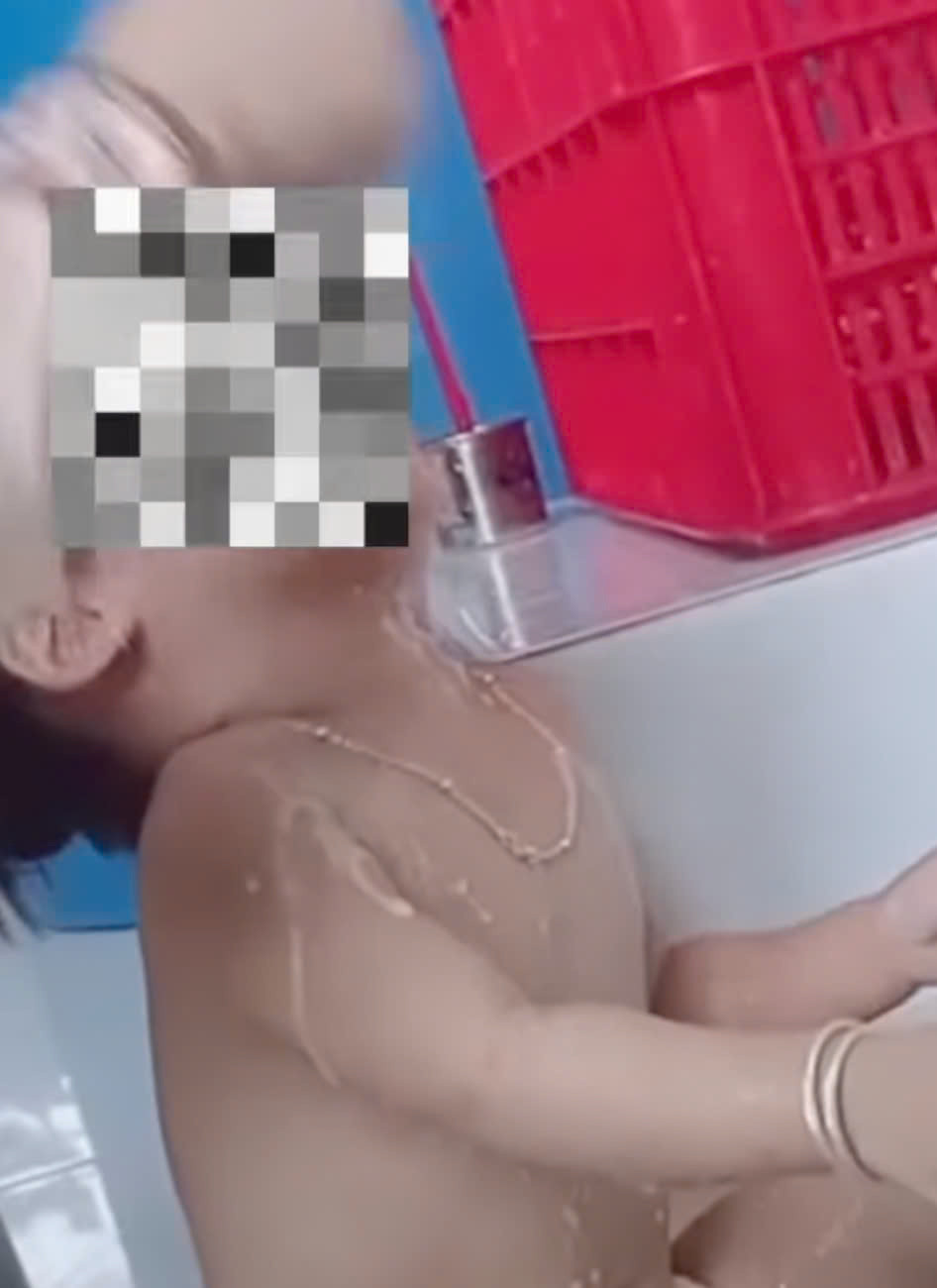 Nhân viên nấu ăn nhồi nhét thức ăn vào miệng trẻ em. Ảnh cắt từ clip.