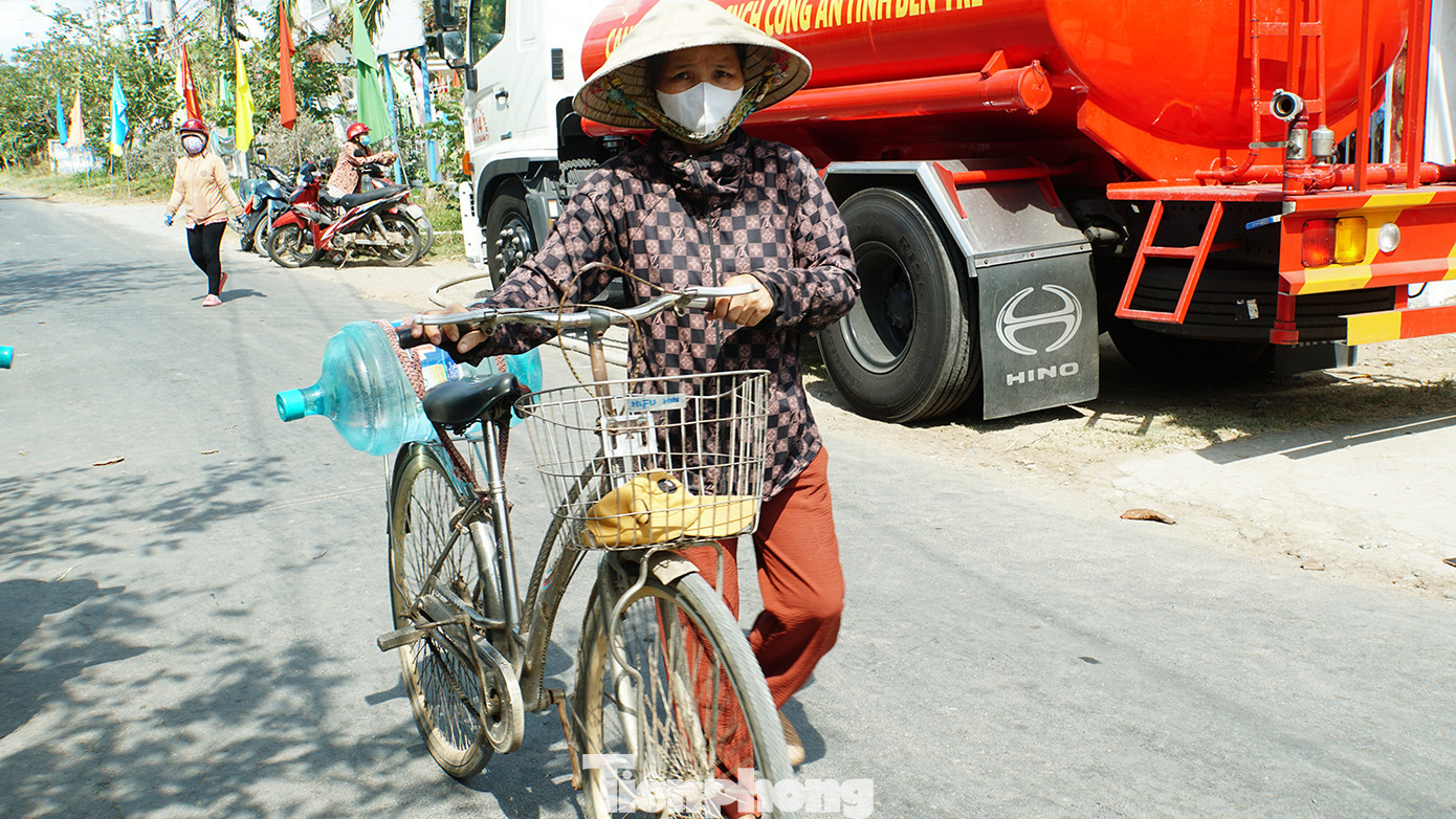Người dân đẩy xe chở nước về nhà. Ảnh: Hòa Hội