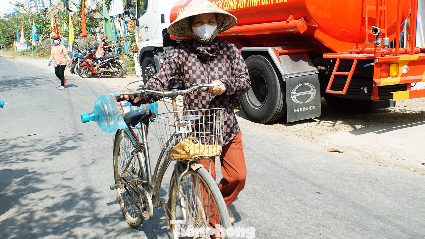 Người dân đẩy xe chở nước về nhà. Ảnh: Hòa Hội