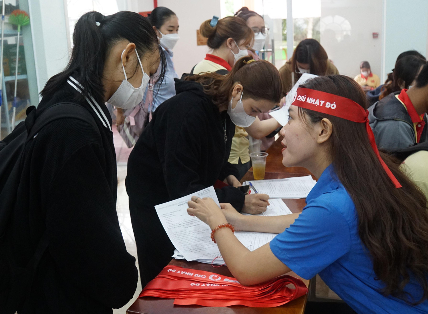 Tình nguyện viên hướng dẫn sinh viên đăng ký hiến máu. - Ảnh: Hòa Hội