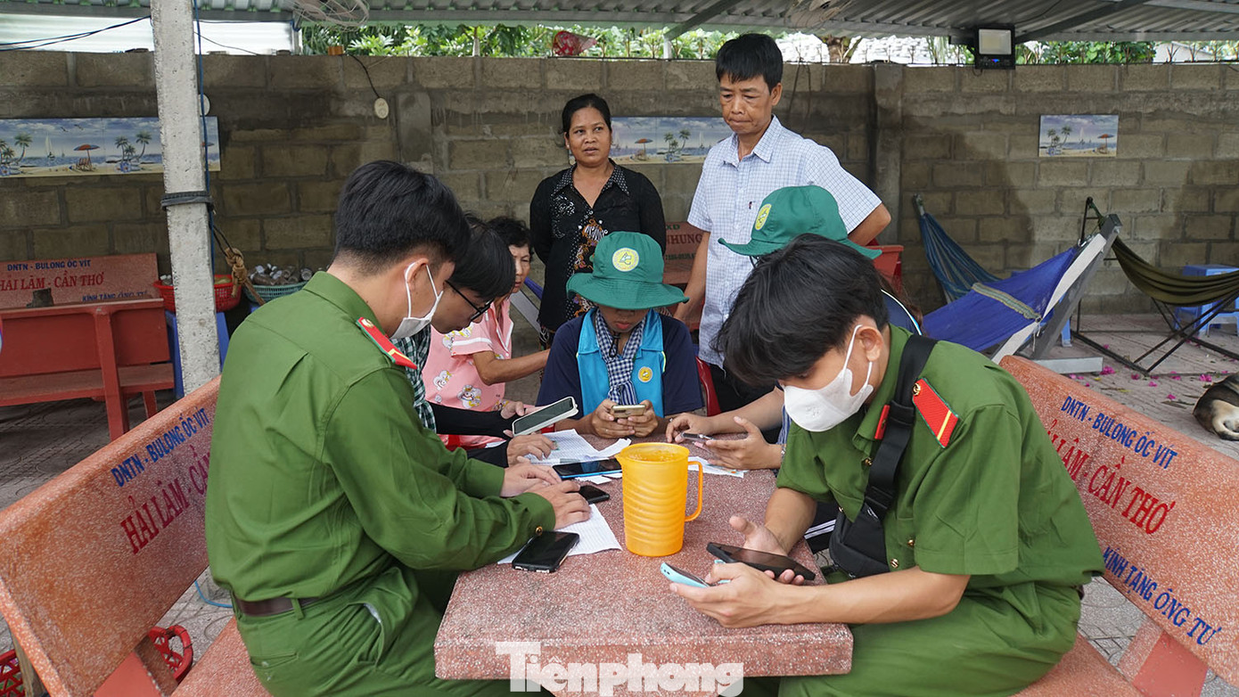 Chiến sĩ công an cùng sinh viên tình nguyện đến tận nhà hỗ trợ người dân cài đặt ứng dụng VNeID.