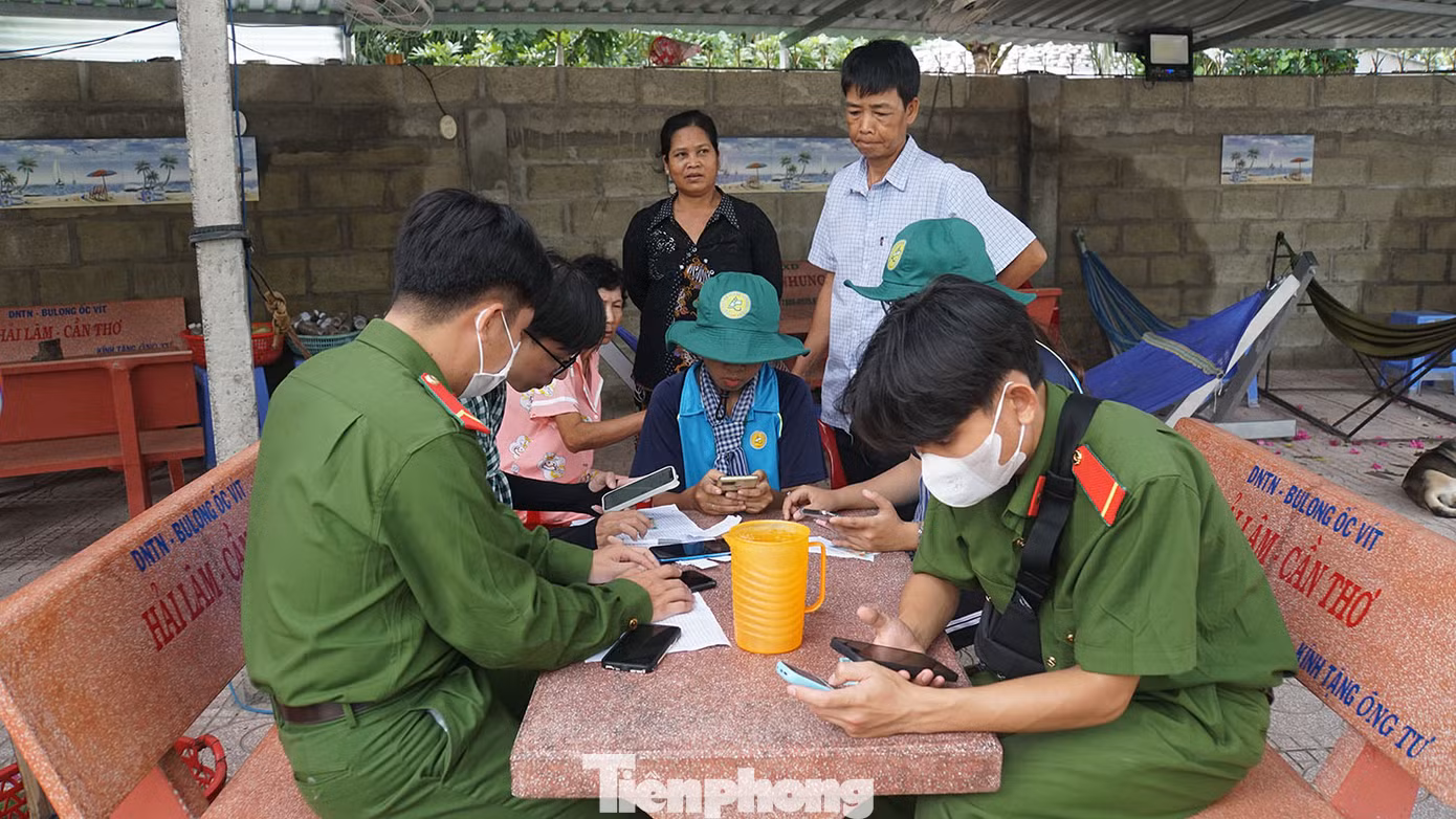 Chiến sĩ công an cùng sinh viên tình nguyện đến tận nhà hỗ trợ người dân cài đặt ứng dụng VNeID.