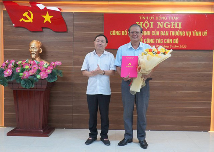 Ông Phan Văn Thắng (bên trái) trao quyết định và tặng hoa chúc mừng ông Nguyễn Lâm Thái Thuận.