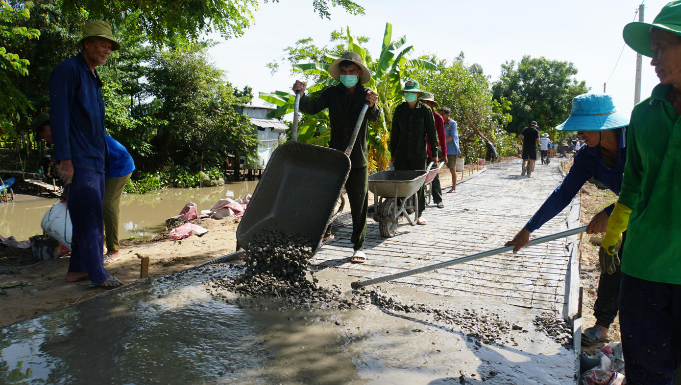Bà Võ Thị Điệp ở ấp Quy Lân 6 vui mừng nói: "Mấy chục năm mới có con đường khang trang như thế này. Trước đây, đặc biệt vào mùa lũ, phải dùng xuồng đưa đón con đi học, vất vả vô cùng”. - Ảnh: Hòa Hội