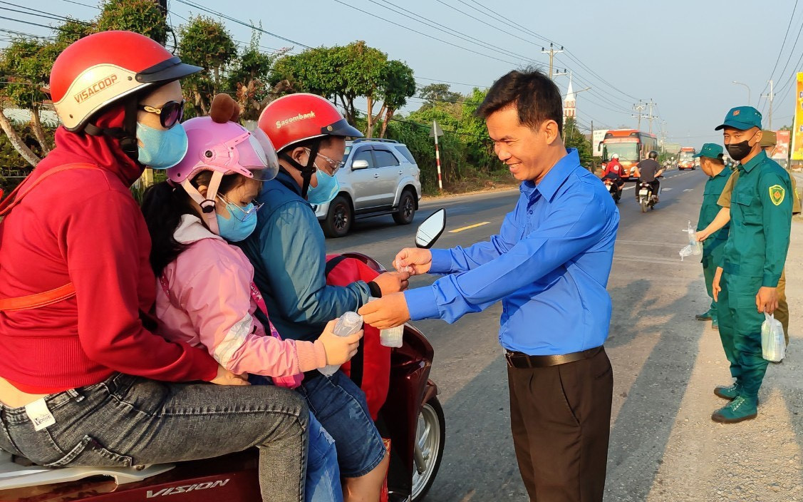 Tại trạm dừng chân nghĩa tình ở huyện Châu Thành, các bạn đoàn viên thanh niên trao tặng nước suối, bánh mì... cho người dân.