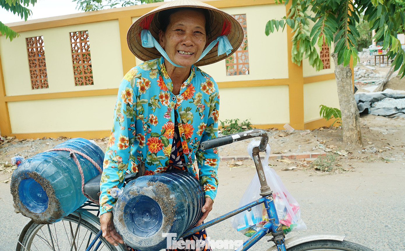 Bà con háo hức, vui mừng khi nhận được bình nước trong thời điểm khó khăn này. Ảnh: Hòa Hội