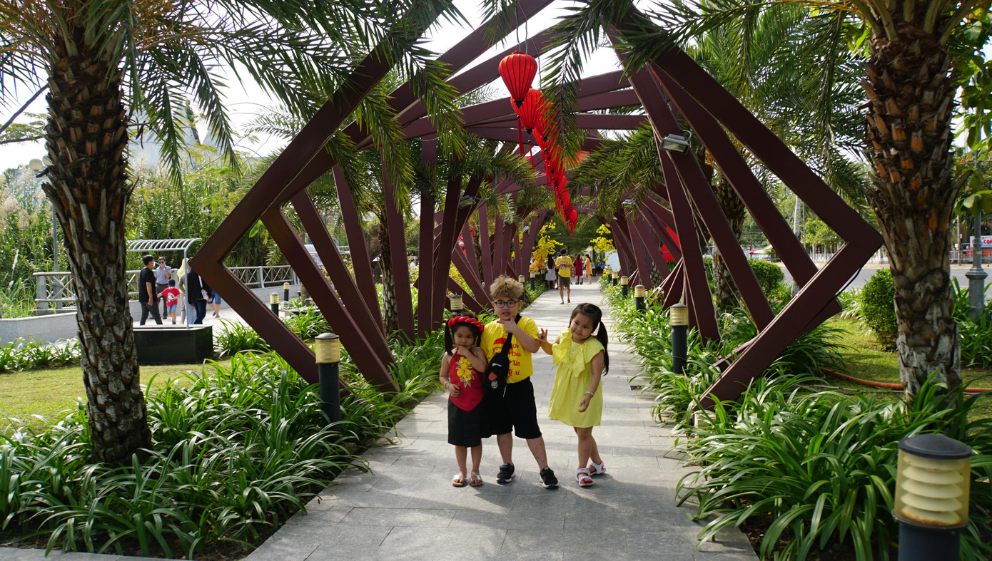 Các em nhỏ tạo dáng chụp ảnh bên vườn hoa xuân Cần Thơ 2022. - Ảnh: Hòa Hội