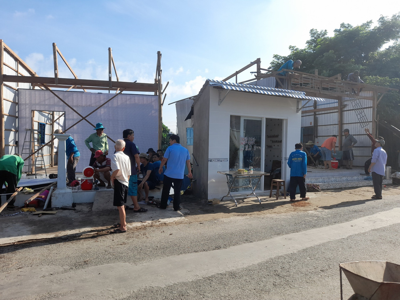 Người dân hỗ trợ di dời nhà bị sạt lở. Ảnh: PV.