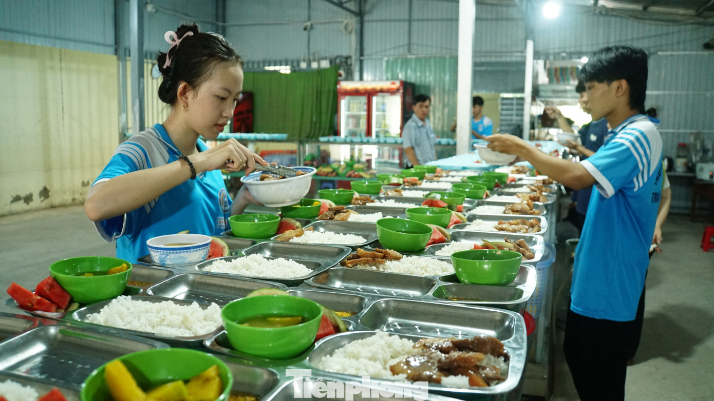 Hơn 8h ngày 28/5, bếp ăn trường THCS - THPT Trần Ngọc Hoằng trở nên nhộn nhịp, với hơn 10 giáo viên, học sinh lớp dưới tới hỗ trợ nấu cơm trưa cho các sĩ tử lớp 12 đang ôn thi Tốt nghiệp THPT tại trường. Ảnh: Hòa Hội