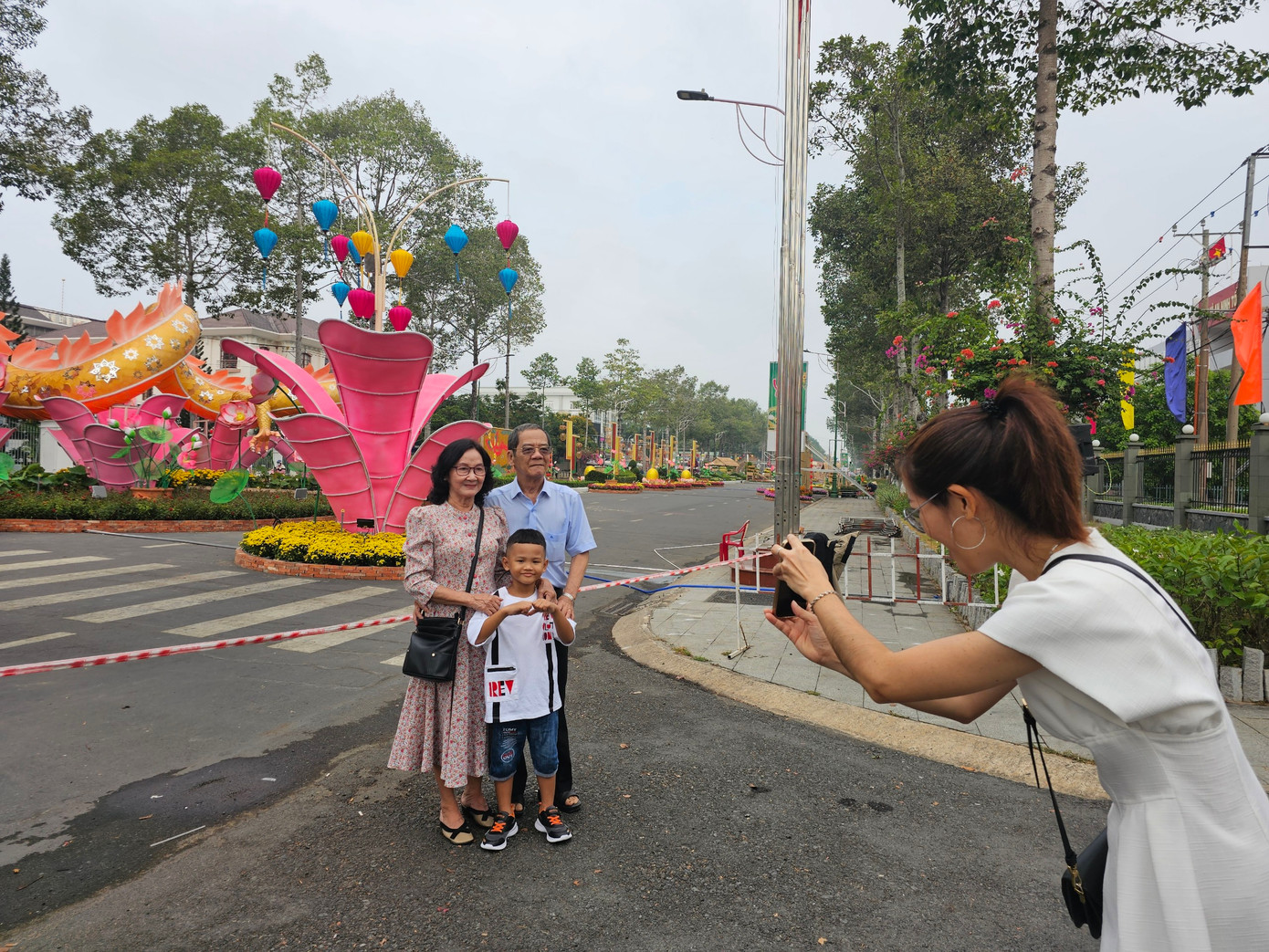Gia đình háo hức chụp ảnh tại đường hoa xuân TP Cao Lãnh trước giờ khai trương. Ảnh: Hòa Hội