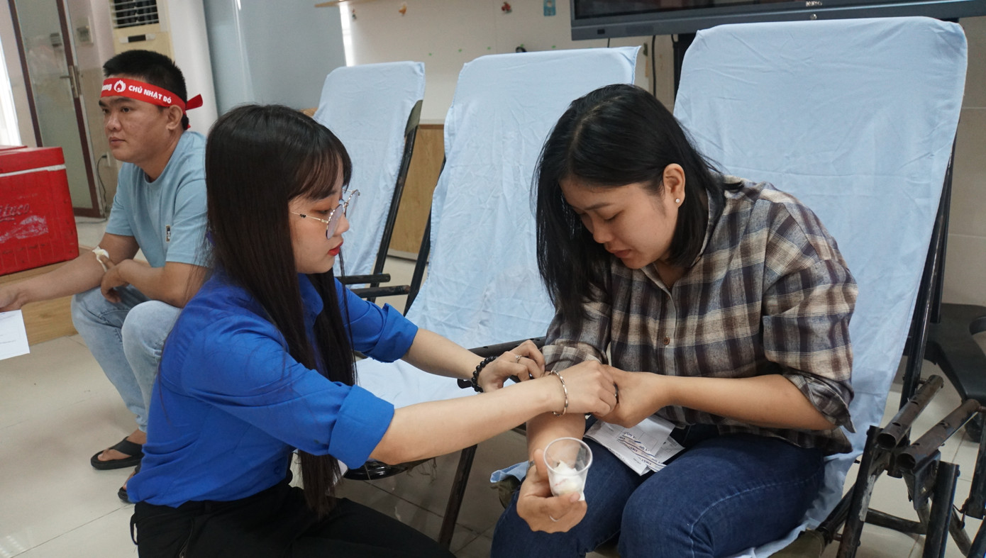 Tình nguyện viên hỗ trợ cán bộ hiến máu.
