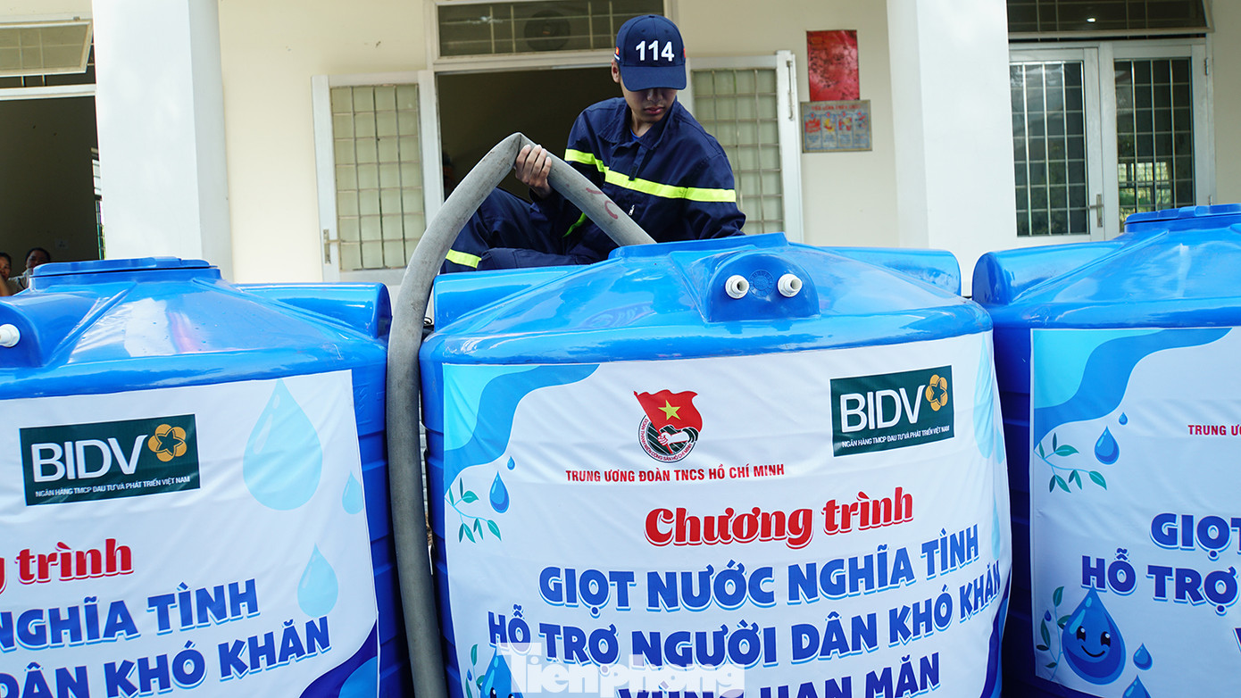 Chiến sĩ Cảnh sát phòng cháy chữa cháy công an tỉnh Bến Tre bơm nước vào bồn được T.Ư đoàn tặng người dân vùng hạn mặn. Ảnh: Hòa Hội