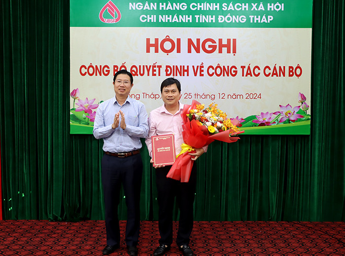 Phó Chủ tịch UBND tỉnh Đồng Tháp - Huỳnh Minh Tuấn (trái) trao quyết định và hoa chúc mừng ông Trần Đăng Nhiên. Ảnh: V. Tiến. Phó Chủ tịch UBND tỉnh Đồng Tháp - Huỳnh Minh Tuấn (trái) trao quyết định và hoa chúc mừng ông Trần Đăng Nhiên. Ảnh: V. Tiến.