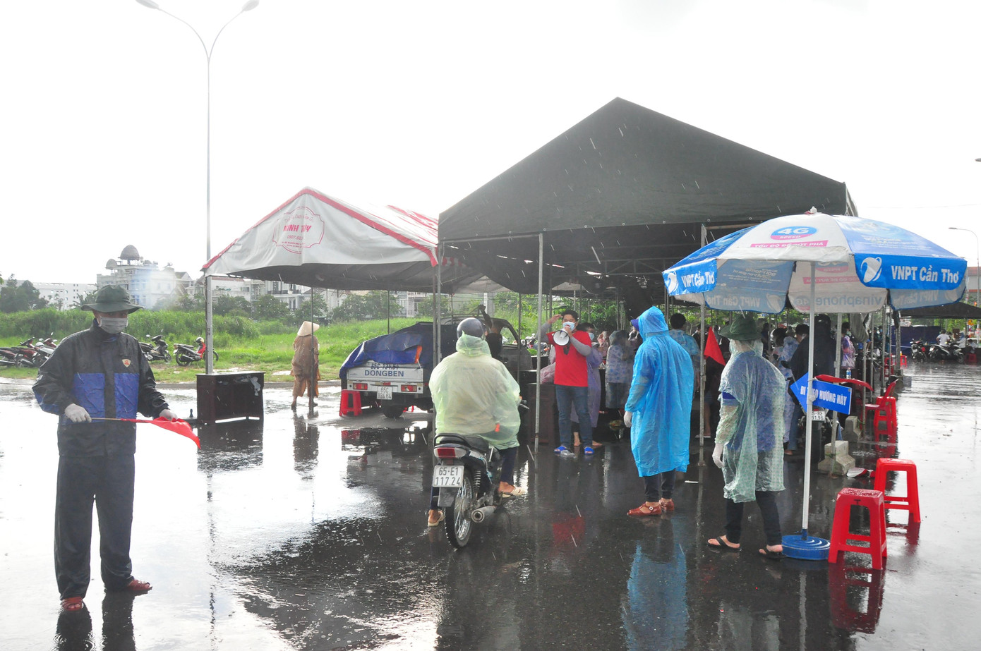 Ghi nhận của phóng viên Tiền Phong tại chốt Siêu thị GO, đường dẫn cầu Cần Thơ, sáng nay trời mưa to, gây khó khăn cho công tác khai báo y tế. Tuy nhiên các bạn vẫn nhiệt tình, dầm mưa hướng dẫn người dân vào vị trí khai báo y tế. Do trời mưa nên tình nguyện viên không thể ngồi trên bàn ghi chép mà chuyển sang dùng điện thoại phỏng vấn ghi âm rồi sau đó mới cập nhật dữ liệu. - Ảnh: Hòa Hội