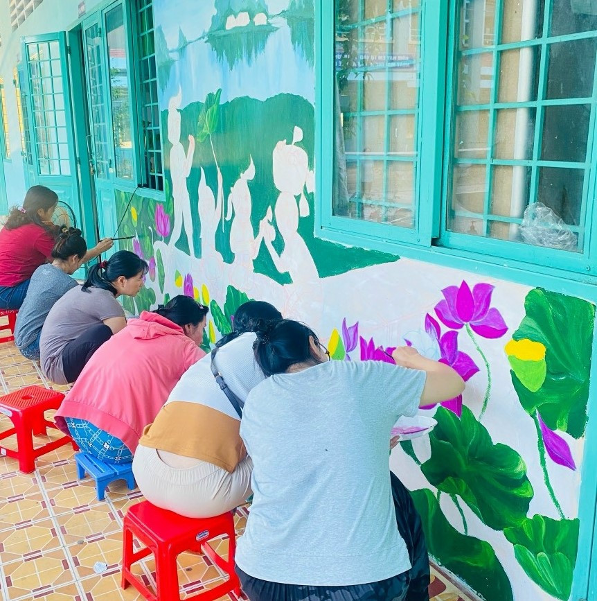 Cô giáo trên địa bàn tỉnh Đồng Tháp vẽ tranh bích họa về sen. Ảnh: BTC