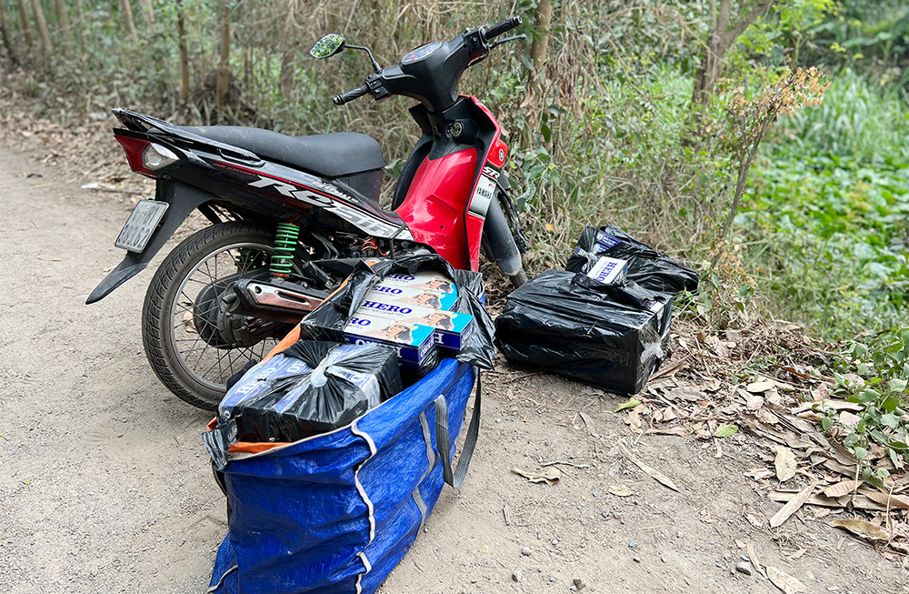Xe máy và các bao đựng thuốc lá bị bỏ lại hiện trường.