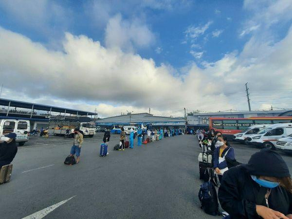 Người dân xếp hàng làm thủ tục lên xe. - Ảnh: Phạm Ngọc Nha