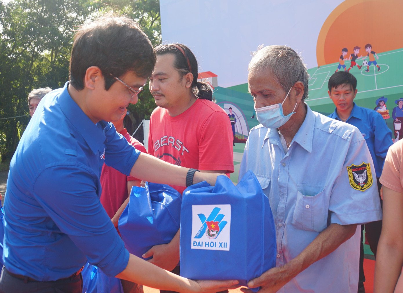 Bí thư thường trực Trung ương Đoàn tặng quà cho người dân. - Ảnh: Hòa Hội