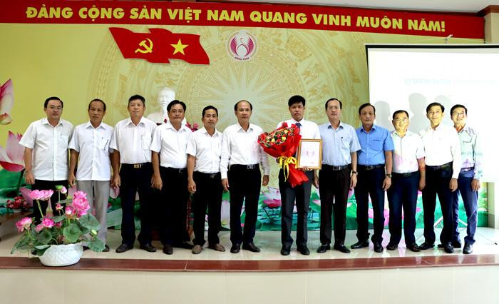 Ông Nguyễn Hoàng Hơn nhận quyết định bổ nhiệm và hoa chúc mừng. - Ảnh: N.Ánh