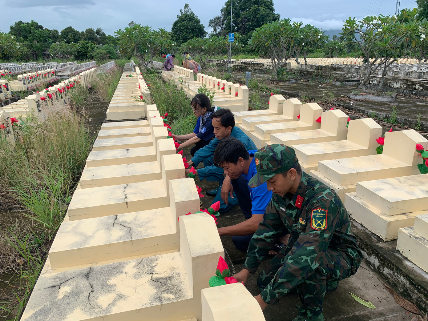 Chiến sĩ và đoàn viên thanh niên thay mới hoa tại nghĩa trang liệt sĩ tỉnh An Giang.