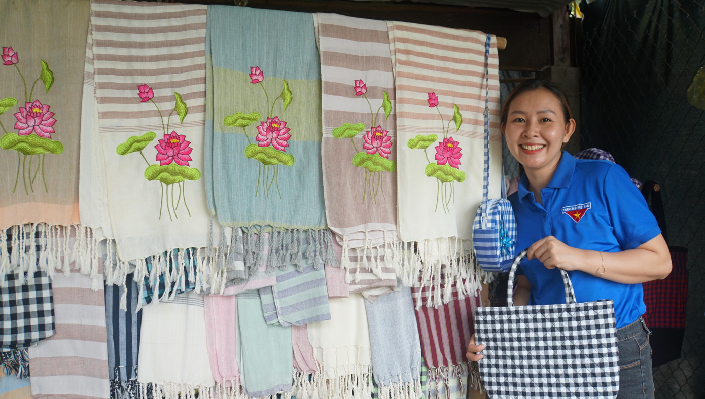 Bạn trẻ thích thú với sản phẩm khăn rằn thêu hoa sen, sếu đầu đỏ và túi xách.