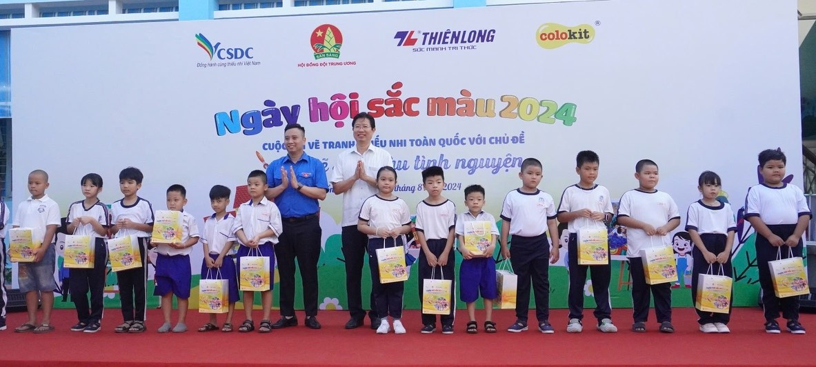 Ông Huỳnh Minh Tuấn - Phó Chủ tịch UBND tỉnh Đồng Tháp và anh Lê Anh Quân - Phó Chủ tịch Hội đồng Đội Trung ương - Giám đốc Trung tâm Hỗ trợ và Phát triển thiếu nhi Việt Nam tặng quà cho thiếu nhi.