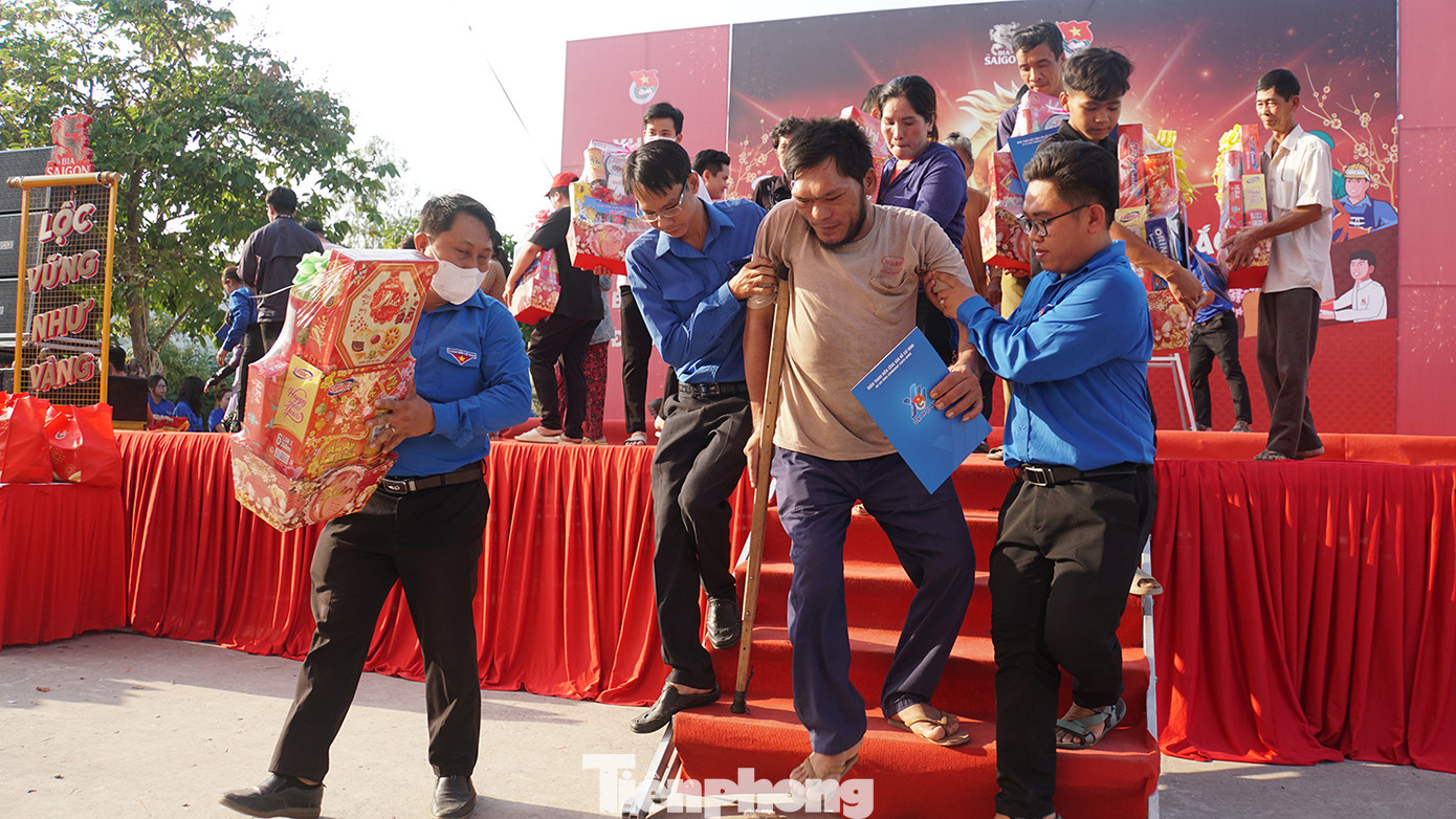 Đoàn viên thanh niên hỗ trợ người dân nhận quà.