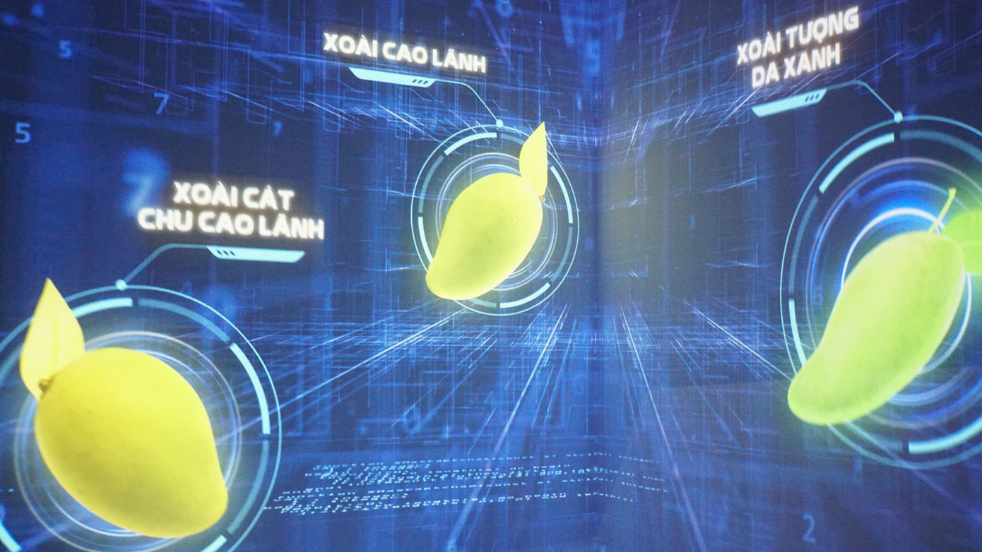 Không gian tường tương tác với 6 giá trị của xoài gồm: Thị trường, hợp tác, liên kết, tăng chất lượng, giảm giá thành, đa dạng hóa sản phẩm. Cách tương tác, người dùng quét mã QR code thông qua camera điện thoại, sau đó sẽ đăng lên story ở Facebook.