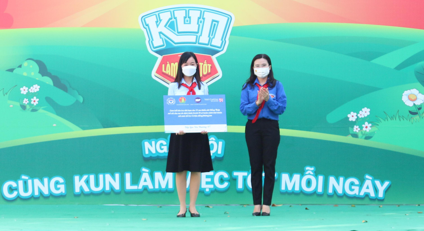 Bí thư Trung ương Đoàn Nguyễn Phạm Duy Trang (áo xanh) trao bảo trợ thiếu nhi mồ côi cha mẹ do đại dịch COVID-19 cho đại diện Tỉnh Đoàn Đồng Tháp. - Ảnh: TĐ ĐT