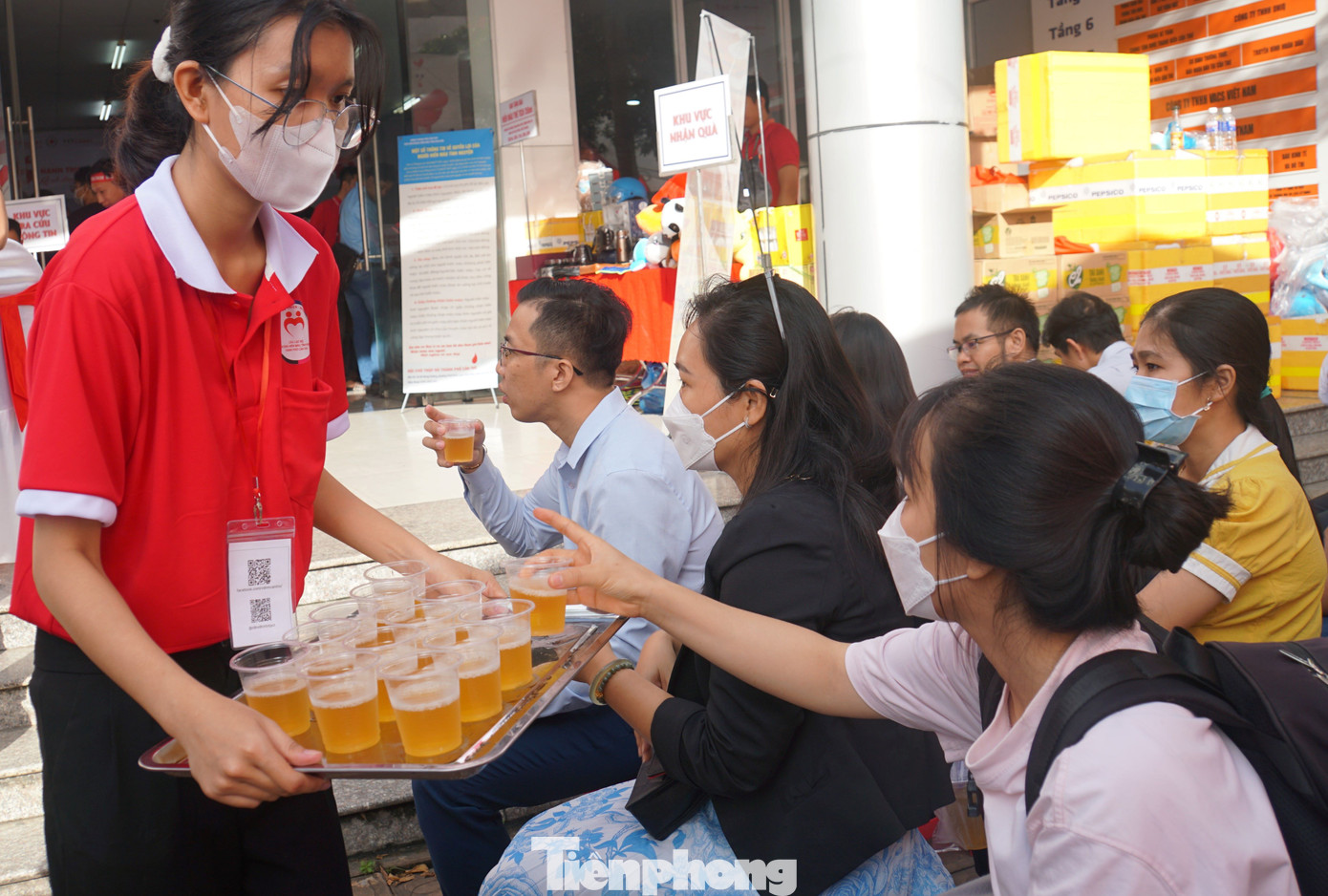 Tình nguyện viên hỗ trợ nước uống cho người tham gia hiến máu.