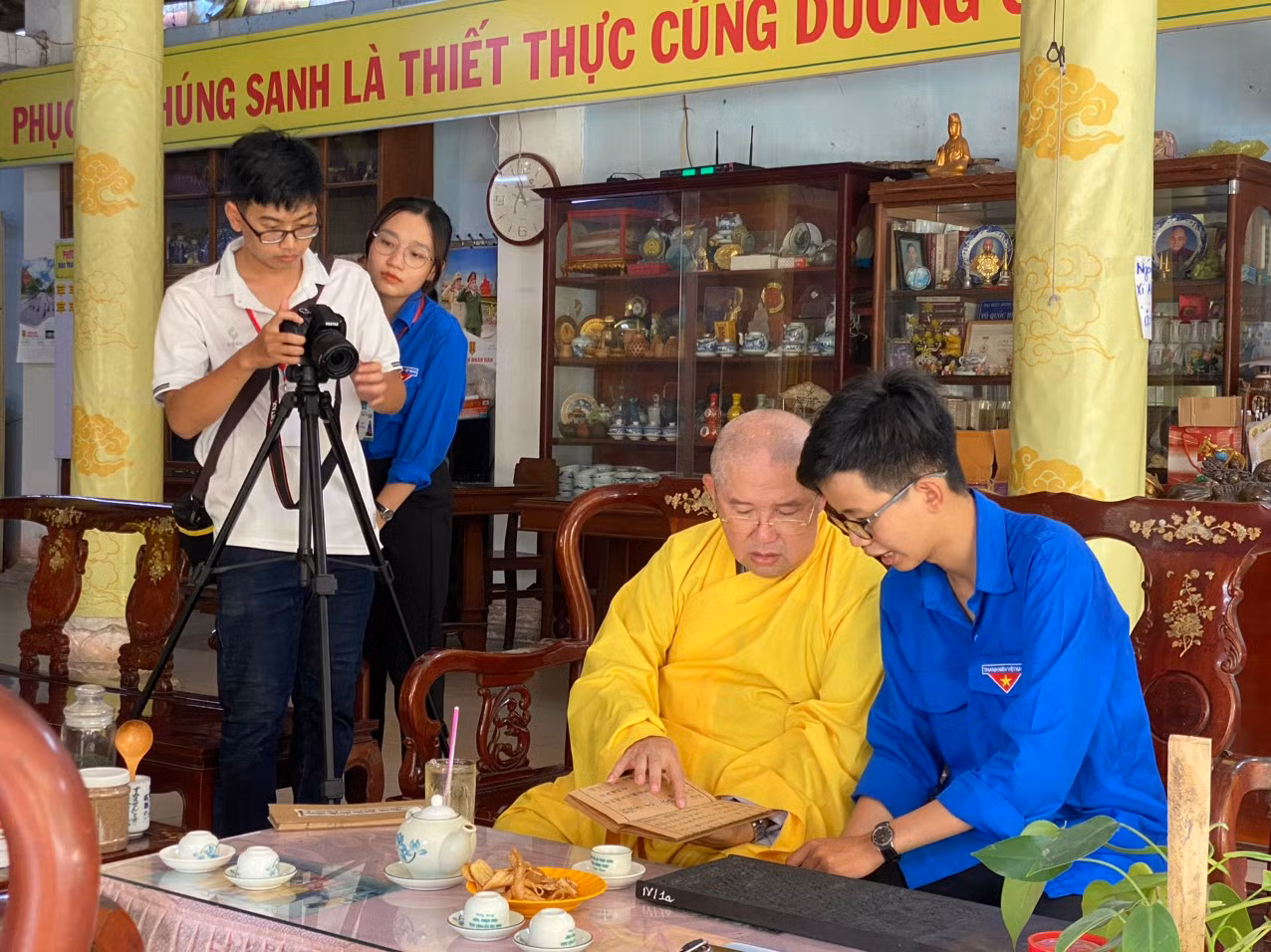 Sư trụ trì chùa Phước Hưng giới thiệu cho các sinh viên tình nguyện về ngôi chùa. Ảnh: Hòa Hội.